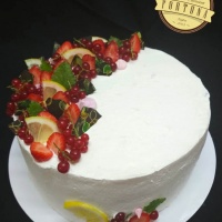 Joghurtos gyümölcsös torta csoki díszekkel és gyümölcsökkel oldalasan (gyümölcsök szezonálisak)